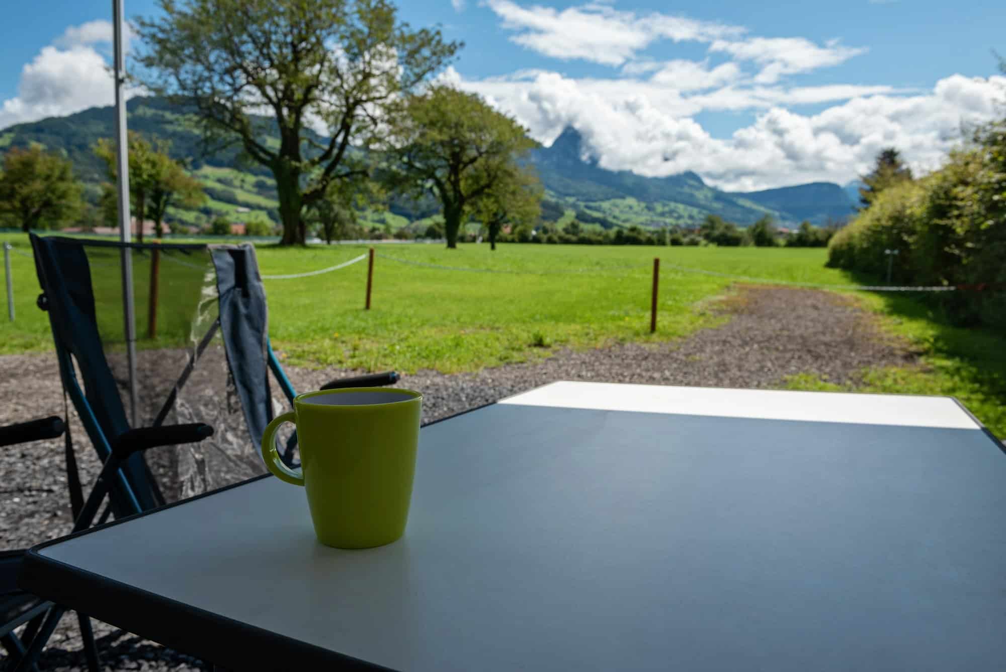 Camping table and chairs in the Switzerland Alps. Great view. Outdoor camping concept