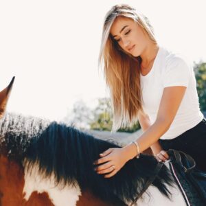 Elegant girl in a farm wiith a horse