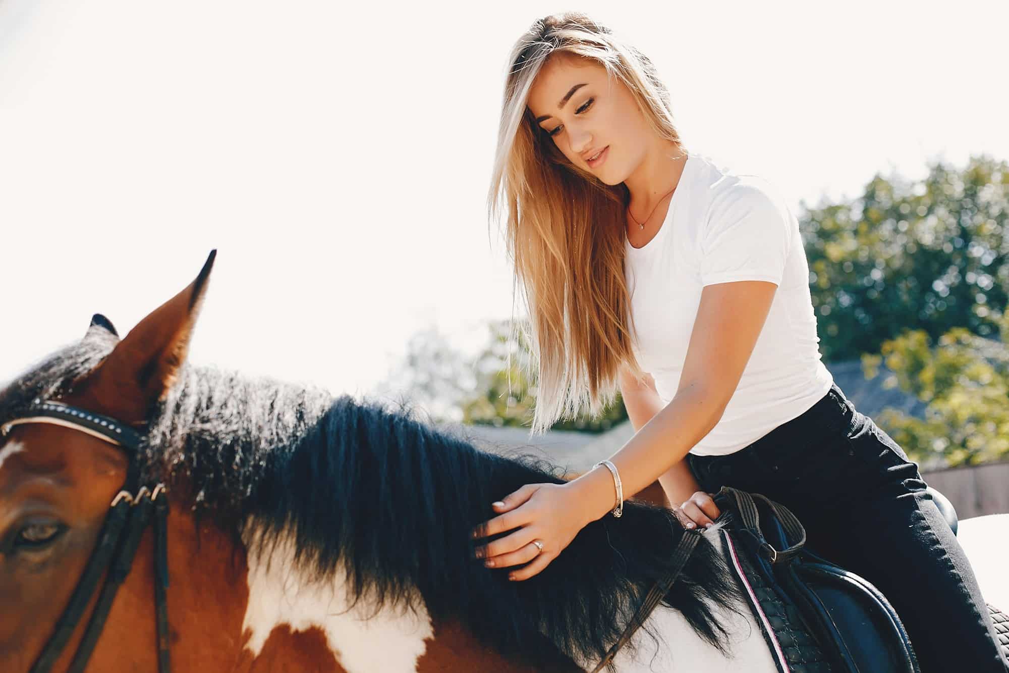 Elegant girl in a farm wiith a horse
