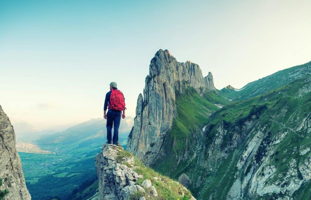 Tourist on a rock in Switzerland. Active rest and tourism in summer time.